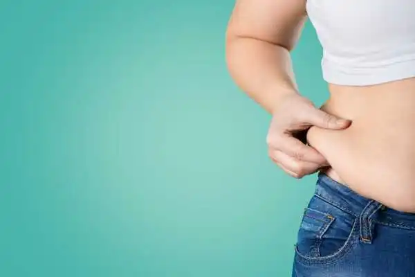 Image of woman pinching her love handles to show weight gain Hucknall under Huthwaite